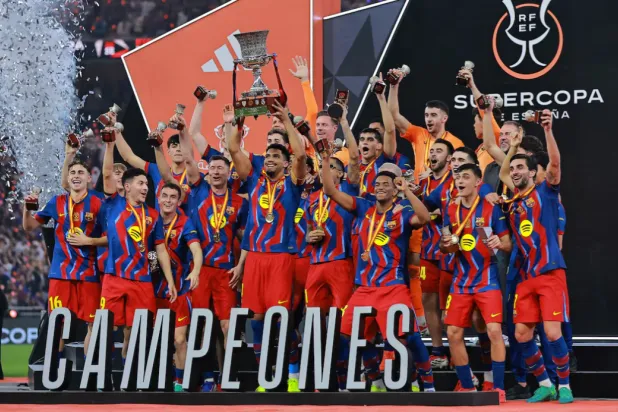 Spanish Super Cup - Final - FC Barcelona v Real Madrid - King Abdullah Sports City Stadium, Jeddah, Saudi Arabia - January 12, 2026 FC Barcelona's Ronald Araujo lifts the trophy with teammates after winning the Spanish Super Cup final REUTERS/Stringer 
