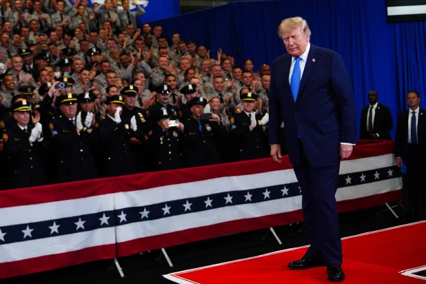 Police officers applaud as President Donald Trump arrives to speak at the David Mack Center for Training and Intelligence, Friday, Aug. 14, 2026, in Garden City, N.Y. (AP Photo/Julia Demaree Nikhinson)