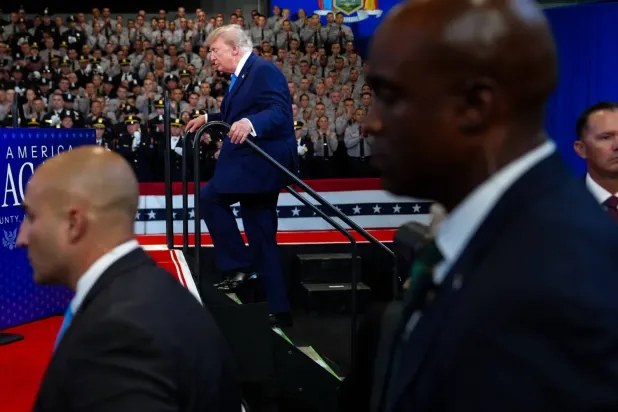 Trump, New York'taki David Mack İstihbarat ve Eğitim Merkezi'nde sahneye doğru yürürken Gizli Servis ajanları teyakkuzda (AP)