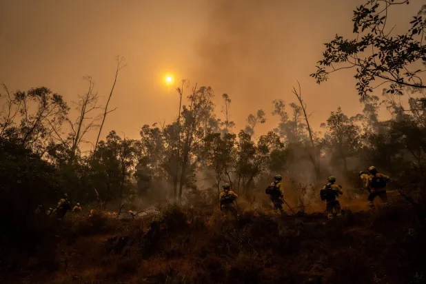 Members of the BRICA 401 and 402 units from Granada advance toward a fireline during a wildfire in Niebla, Huelva, Spain, August 8, 2026. REUTERS/Mikel Konate