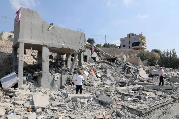 People inspect a damaged building after an Israeli airstrike on the village of Ansar, southern Lebanon, 15 August 2026. EPA/WAEL HAMZEH
