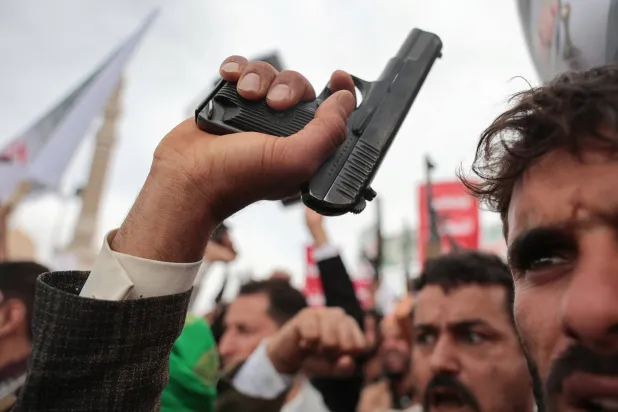 عنصر حوثي يرفع مسدساً خلال حشد للجماعة بصنعاء (رويترز)