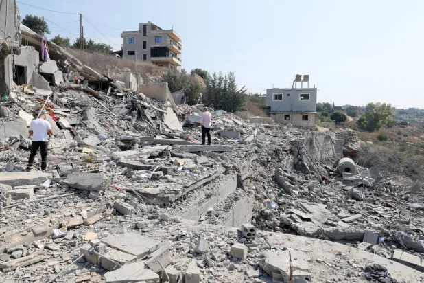 People inspect a damaged building after an Israeli airstrike on the village of Ansar, southern Lebanon, 15 August 2026. EPA/WAEL HAMZEH