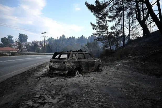 A burnt vehicle after a fire that broke out in the summer resort of Siviri, Chalkidiki, northern Greece, 14 August 2026. (EPA) 