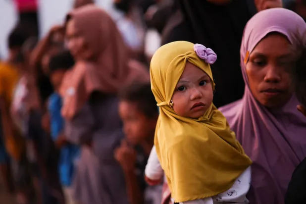 عائلة إندونيسية هاربة إلى ملجأ مؤقت (رويترز)