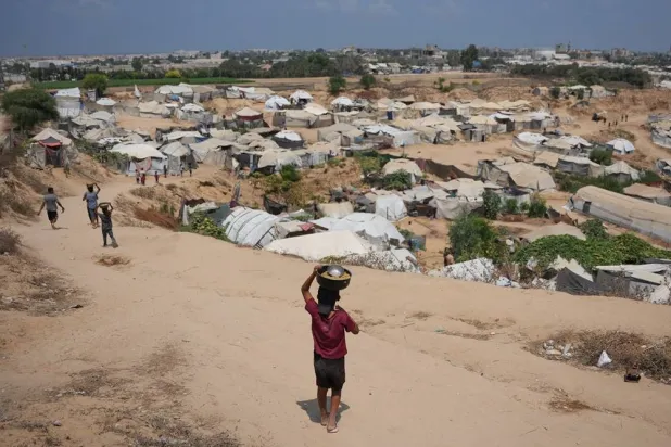  Displaced Palestinian children carry food portions in Deir al-Balah, central Gaza Strip, Friday, Aug 14, 2026. (AP) 