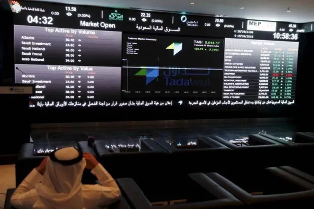 مستثمر يتابع شاشات التداول في «السوق السعودية» (رويترز)