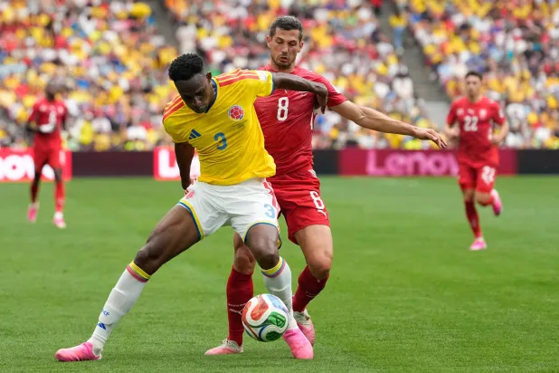 Colombia's Jhon Lucumí, left, and Switzerland's Remo Freuler battle for the ball during the World Cup round of 16 soccer match between Switzerland and Colombia in Vancouver, British Columbia, July 7, 2026. (AP)