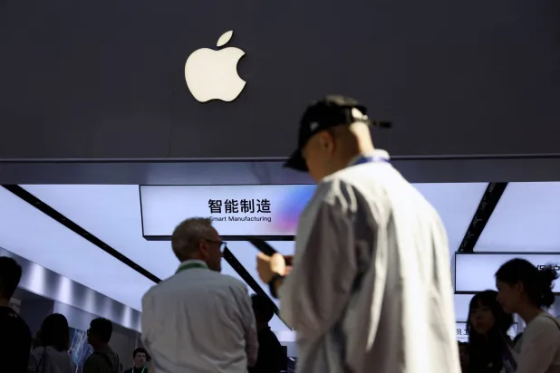 FILE PHOTO: People walk past a booth showcasing Apple's suppliers during the China International Supply Chain Expo (CISCE) in Beijing, China June 22, 2026. REUTERS/Florence Lo/File Photo