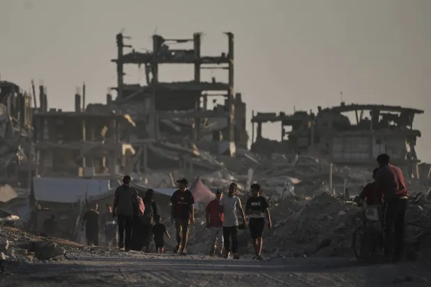  Palestinians walk amid the ruins of buildings destroyed by Israeli airstrikes during the war with Hamas, in Gaza City, Monday, Aug. 17, 2026. (AP) 