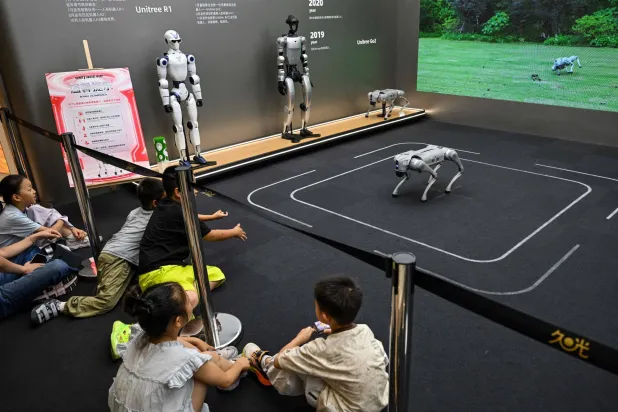  Children look at a remote-controlled robot by Unitree Robotics while visiting the Unitree Robotics Embodied Intelligence Experience Center in the Jing' an district in Shanghai on August 17, 2026. (AFP) 