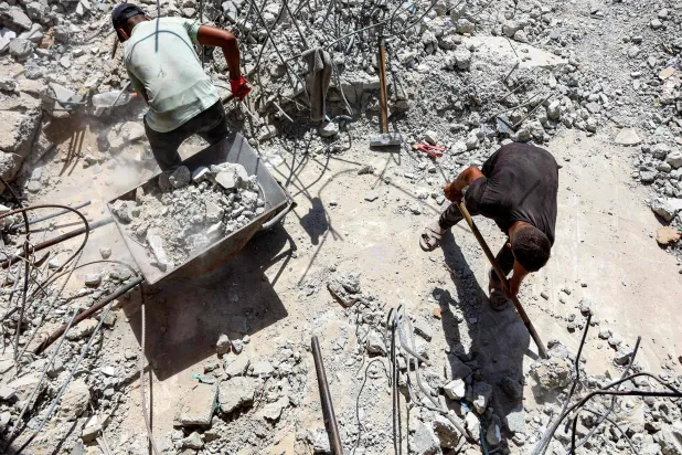 Salvage workers shovel the scrapped rubble of a building that was destroyed during Israel's war against Hamas in Gaza, to use the recycled remains in the future, in Gaza City on August 16, 2026. (Photo by Omar AL-QATTAA / AFP)