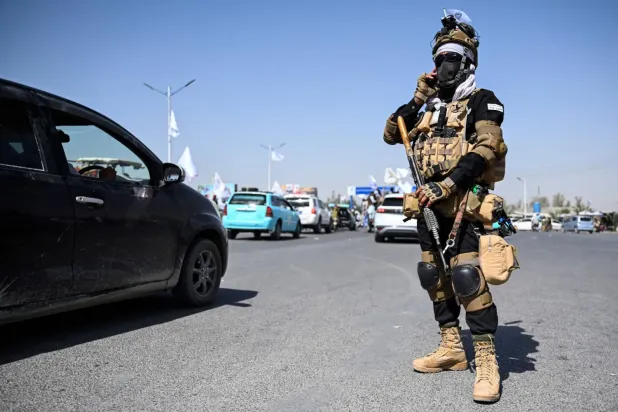 Taliban'ın iktidara dönüşünün beşinci yıl dönümü kutlamaları sırasında bir Taliban güvenlik görevlisi 15 Ağustos 2026'da Kandahar'da bir yolda duruyor (AFP)