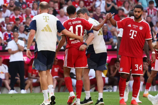 Munich's Jamal Musiala, center, leaves the pitch due to an injury during a pre-season soccer match between FC Bayern Munich and RB Leipzig in Munich, Germany, Saturday, Aug. 15, 2026. (Karl-Josef Hildenbrand/dpa via AP)
