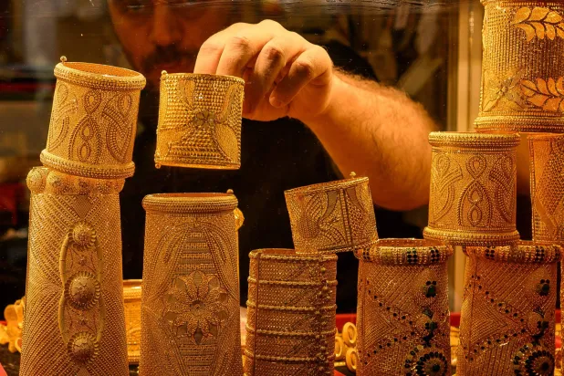 موظف يعرض أساور ذهبية للبيع في متجر ذهب في السوق الكبير بإسطنبول (أ.ف.ب)