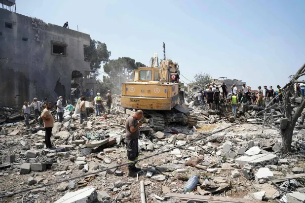 آليات وفرق إسعاف وسكان يفتشون موقع غارة جوية إسرائيلية استهدفت حياً في قرية دير الزهراني جنوب لبنان - 15 أغسطس 2026 (أ.ف.ب)