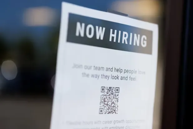 A "now hiring" sign is displayed on a local business after, US employment growth slowed more than expected in July, in Encinitas, California, US August 1, 2025. REUTERS/Mike Blake 