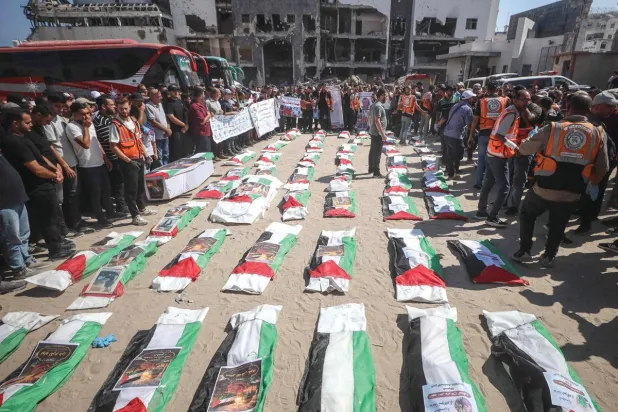 
مشيعون يلتفون حول رفات فلسطينيين قتلوا في ضربات خلال حرب غزة قبيل دفنهم بمدينة غزة أمس (أ.ف.ب)