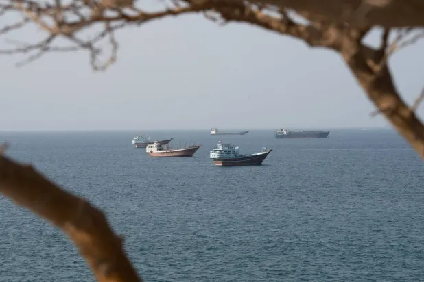 سفن بالقرب من مضيق هرمز كما تُرى من مسندم بعُمان (رويترز)