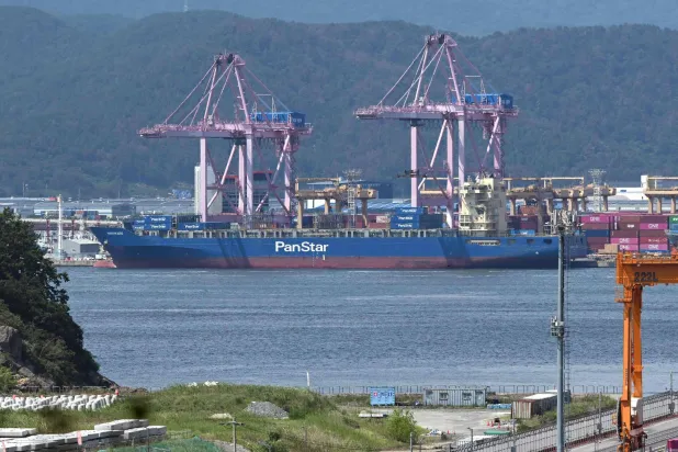The container ship "Panstar Acro" is anchored to load containers at Busan New Port in Busan on August 22, 2026, as the vessel is scheduled to sail to Europe via the Arctic to test the commercial viability of the shipping route opened by melting ice. (AFP) 