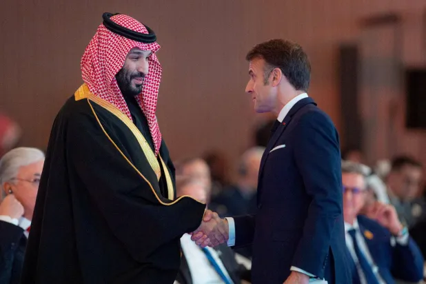 ولي العهد الأمير محمد بن سلمان مصافحاً الرئيس الفرنسي إيمانويل ماكرون خلال زيارة الأخير للسعودية في ديسمبر 2024 (رويترز)
