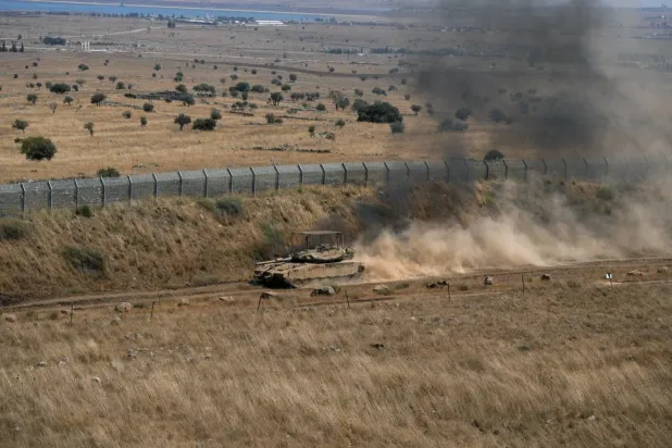 İsrail'e ait bir tank, işgal altındaki Golan Tepeleri ile Suriye arasındaki ateşkes hattı boyunca ilerliyor (Reuters)