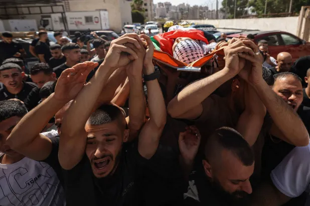 Mourners carry the body of Palestinian Islam Ajouri, 14, at Rafidia Hospital in Nablus in the Israeli-occupied West Bank, on August 23, 2026. (Photo by JAAFAR ASHTIYEH / AFP)