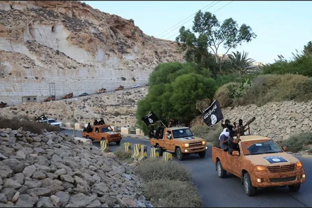 مسلحون يرفعون راية تنظيم «داعش» في درنة بليبيا عام 2015 (أرشيفية - رويترز)