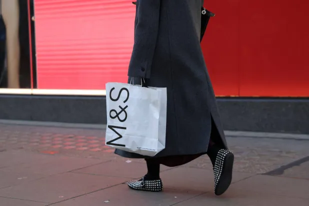 A shopper carries a Marks & Spencer shopping bag in London, Britain, January 2, 2025. (Reuters)