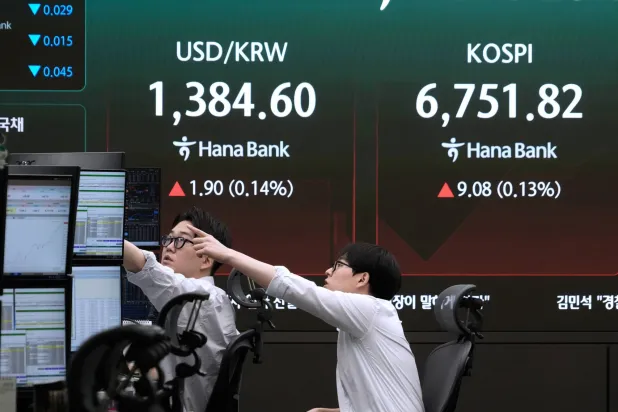 متداولو العملات يراقبون شاشات تعرض مؤشر «كوسبي» وسعر صرف العملات الأجنبية بين الدولار الأميركي والوون الكوري الجنوبي في غرفة تداول العملات الأجنبية بمقر بنك هانا في سيول (أ.ب)