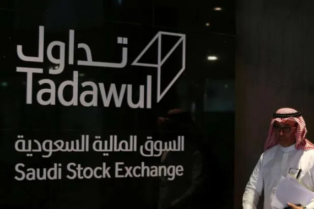 رجل يعبر أمام شعار السوق السعودية (أ.ف.ب)