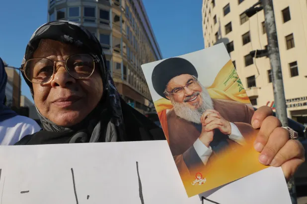 مناصرة لـ«حزب الله» تحمل صورة أمينه العام السابق حسن نصر الله خلال حراك في وسط بيروت ضد المفاوضات اللبنانية مع إسرائيل برعاية أميركية (إ.ب.أ)