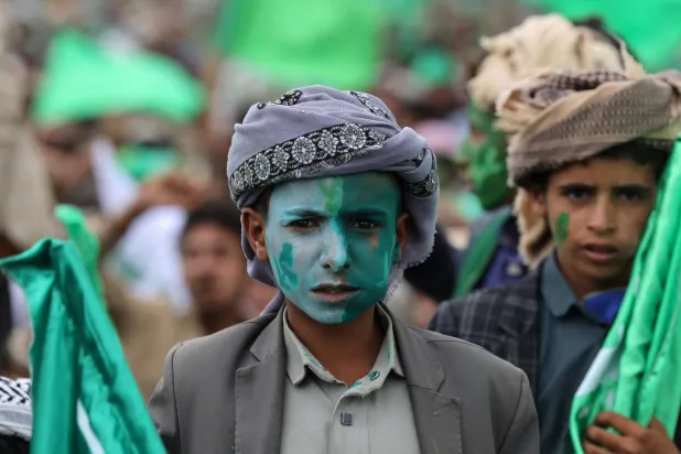 صبي ملطخ وجهه بالألوان يشارك في حشد للحوثيين بصنعاء (رويترز)