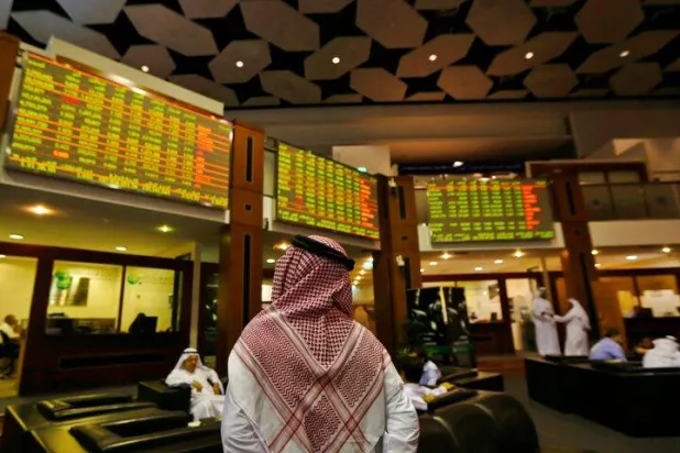 مستثمر يتابع الأسهم في سوق دبي (رويترز)