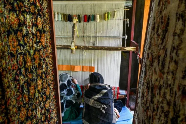 (FILES) Kashmiri craftswomen weave silk carpets at a factory in Srinagar on May 6, 2026. Tauseef MUSTAFA / AFP

