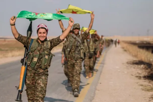 Kurdish fighters gesture while carrying their parties' flags in Tel Abyad of Raqqa governorate after they said they took control of the area June 15, 2015. REUTERS/Rodi Said/Files 