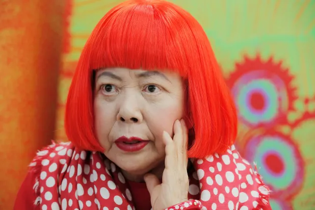  Japanese avant-garde artist Yayoi Kusama, wearing a bright red wig and a Louis Vuitton polka dot scarf, speaks during an interview at her studio in Tokyo, on Aug. 1, 2012. (AP) 