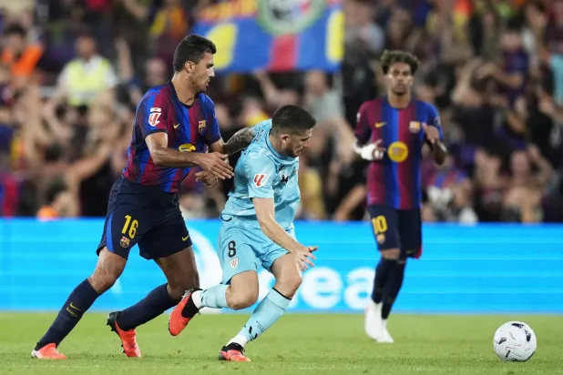 لاعب برشلونة رودري (يسار) يتنافس على الكرة مع أويهان سانسيت لاعب أتلتيك بلباو (إ.ب.أ)