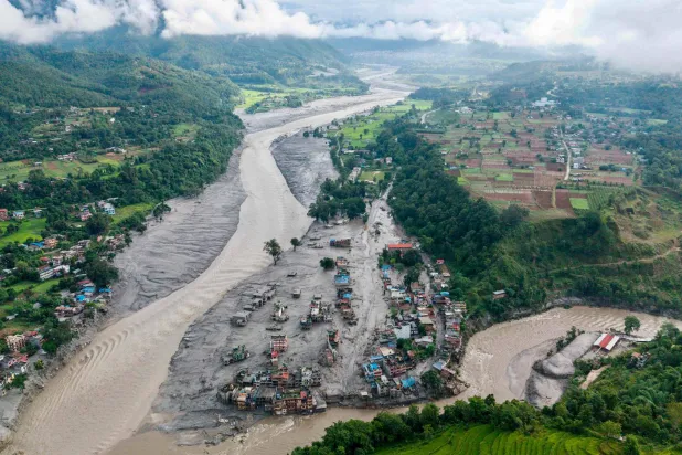 An aerial view shows houses lying deluged in sludge after flash floods at Devighat, Bidur Municipality, along the confluence of the Trishuli and Tadi rivers in Nepal's Nuwakot district on August 27, 2026. (AFP) 