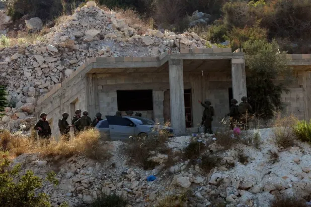 Israeli troops search the area following an airstrike that killed three Palestinians near the West Bank city of Jenin, 28 August 2026. (EPA)