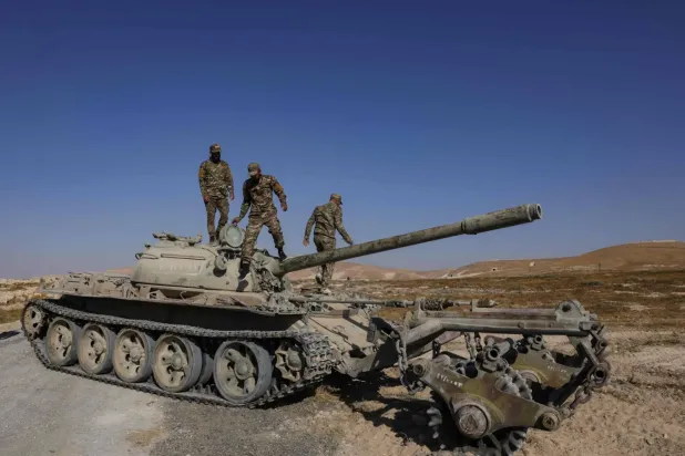 Suriyeli askerler, mayın temizleme operasyonu sırasında Suriye Savunma Bakanlığı Askeri Mühendislik Birimi’ne ait bir tankın üzerinde, (AFP)