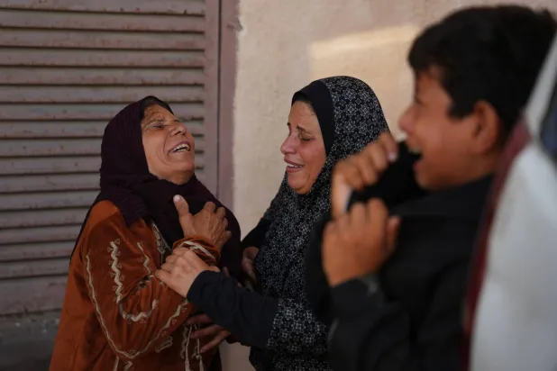 فلسطينيات يبكين بجوار جثمان حمودة العطار الذي قتله الجيش الإسرائيلي في وسط قطاع غزة (أ.ب)