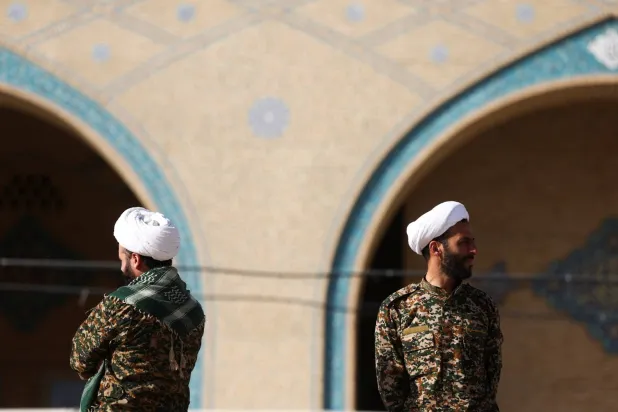 عنصران من قوات «الباسيج» خارج مصلّى طهران الكبير خلال مراسم وداع المرشد الإيراني علي خامنئي الجمعة (رويترز)