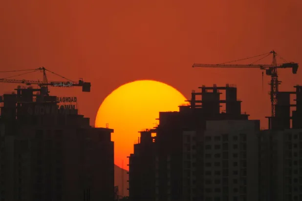 The sun sets behind apartment buildings in Baghdad, Iraq, Friday, Aug. 28, 2026. (AP)