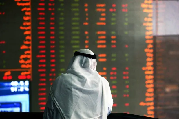 مستثمر في البورصة الكويتية يتابع شاشة أسهم متراجعة (أ.ف.ب)