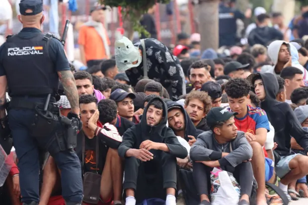 مهاجرون ينتظرون خارج مركز إيواء المهاجرين المؤقت "لوما كولمينار" في سبتة، إسبانيا (إ.ب.أ)