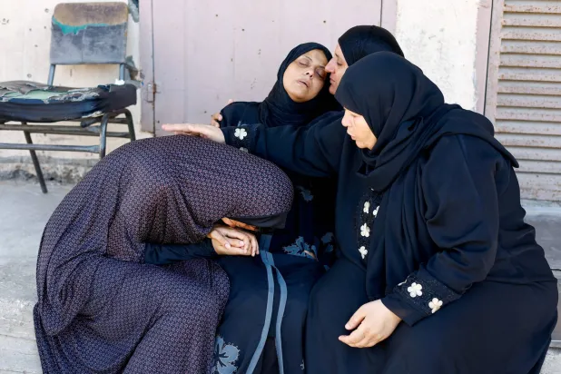 أقارب قتلى فلسطينيين في مستشفى شهداء الأقصى بدير البلح بمدينة غزة (رويترز)