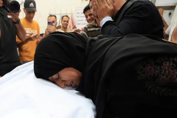 فلسطينيون متأثرون خلال تشييع أحد قتلى الغارات الإسرائيلية في مدينة غزة الاثنين (رويترز)