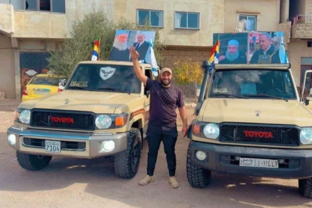 Süveyda’da Hicri destekçileri, İsrail Başbakanı Binyamin Netanyahu’nun fotoğrafını Şeyh Hikmet el-Hicri’nin fotoğrafıyla birlikte taşıyor. (Arşiv)