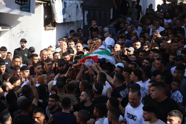 مشيّعون فلسطينيون يحملون جثمان المراهق إسلام أحمد العجوري خلال جنازته في مخيم عسكر للاجئين بالقرب من مدينة نابلس في الضفة الغربية يوم 23 أغسطس 2026 (إ.ب.أ)